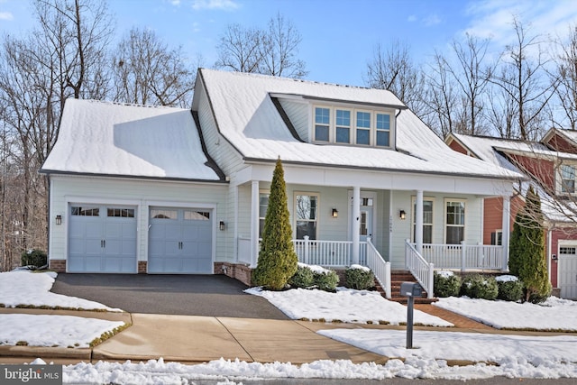 view of front of house featuring driveway, a garage, and a porch