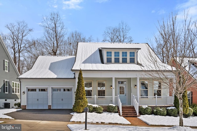 view of front facade with an attached garage, aphalt driveway, central AC unit, and a porch