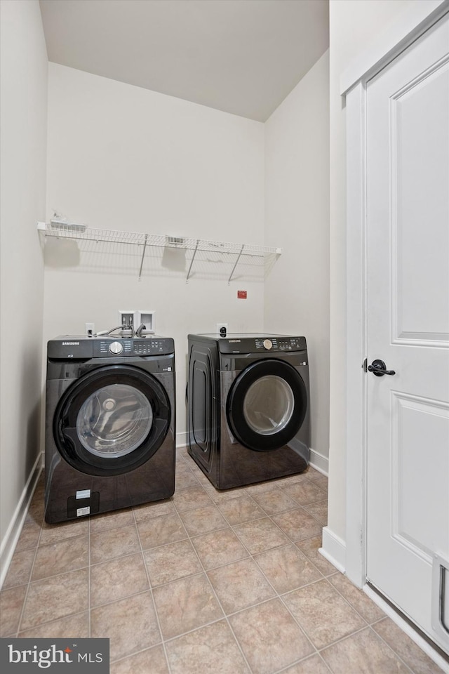 laundry room with laundry area, washer and clothes dryer, baseboards, and tile patterned floors