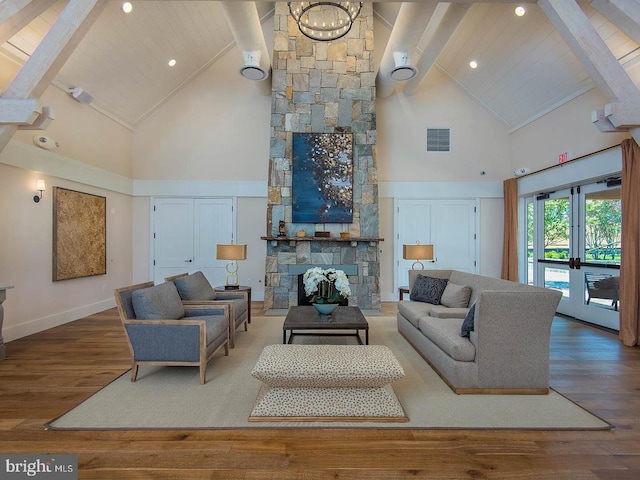 living room featuring high vaulted ceiling, a stone fireplace, wood finished floors, baseboards, and beam ceiling