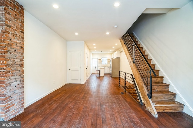 foyer featuring recessed lighting, baseboards, stairs, and dark wood-style flooring