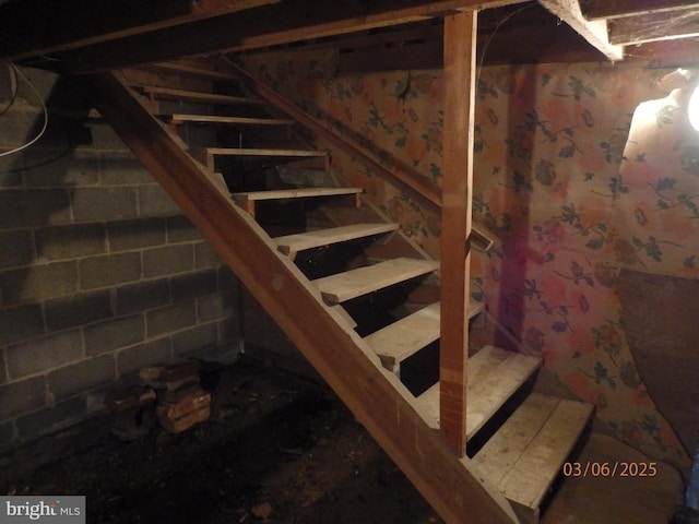 staircase with concrete block wall