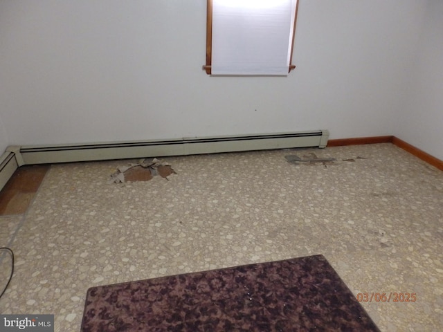 unfurnished room featuring a baseboard radiator and baseboards