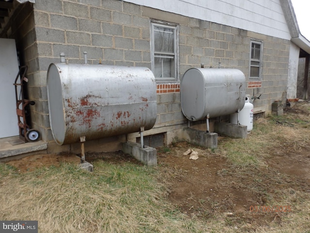 exterior details featuring concrete block siding and heating fuel