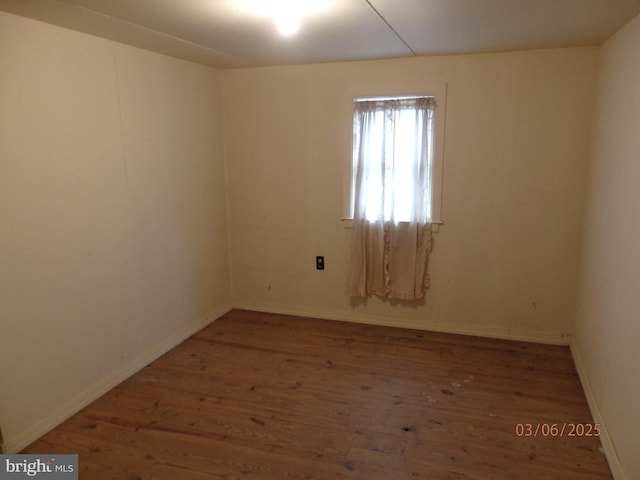 unfurnished room featuring wood finished floors and baseboards