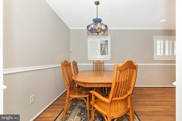 dining room featuring wood finished floors, baseboards, a chandelier, and ornamental molding