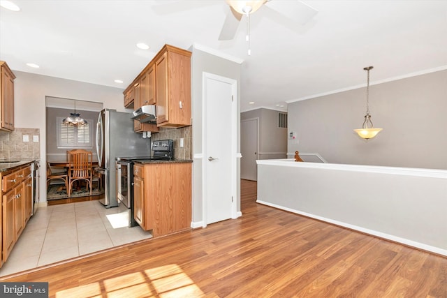 kitchen featuring under cabinet range hood, light wood-style flooring, appliances with stainless steel finishes, and ornamental molding