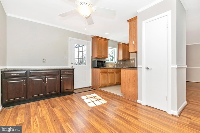 kitchen featuring light wood-type flooring, decorative backsplash, and crown molding