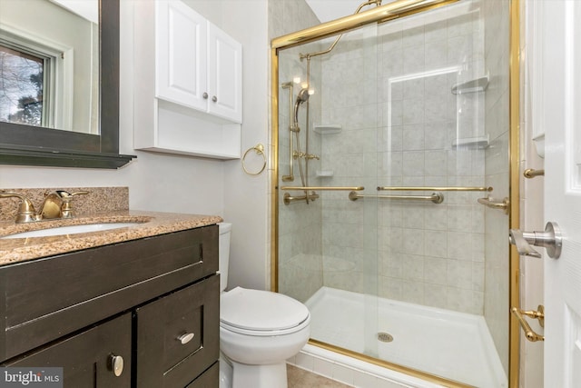 bathroom with a shower stall, toilet, and vanity