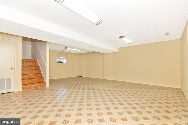 basement with stairway, baseboards, and visible vents