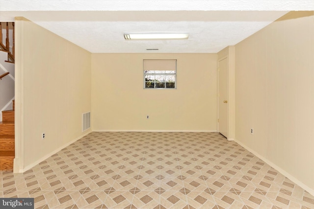 empty room featuring visible vents, baseboards, and stairs