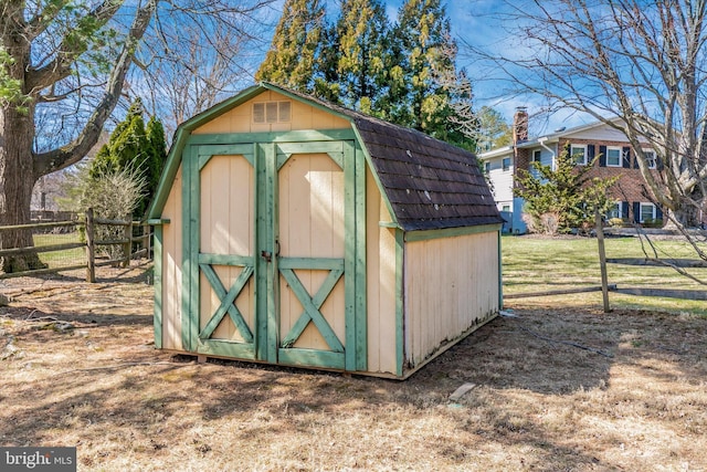 view of shed featuring fence