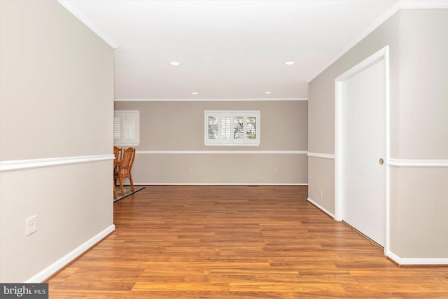 unfurnished room featuring recessed lighting, crown molding, light wood-type flooring, and baseboards