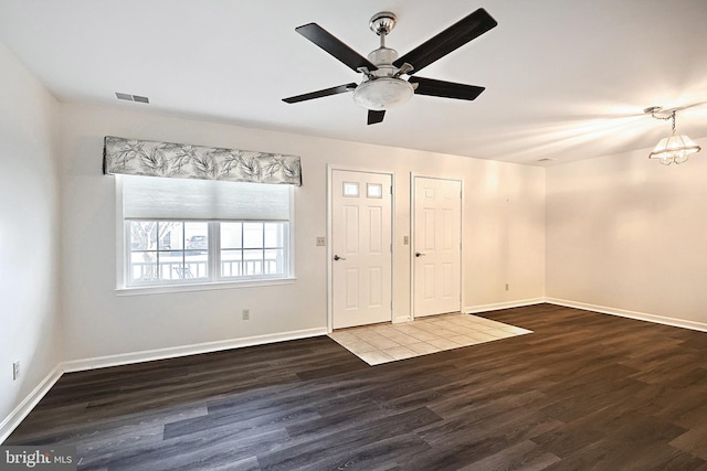 interior space with visible vents, ceiling fan, baseboards, and wood finished floors