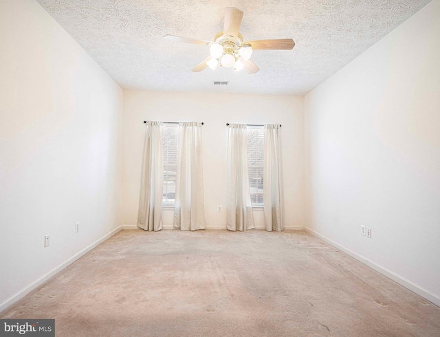 unfurnished room featuring visible vents, carpet flooring, a textured ceiling, and baseboards