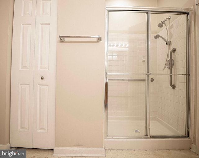 full bathroom featuring a shower stall and baseboards