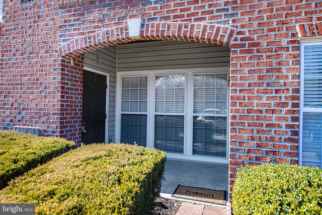 property entrance with crawl space and brick siding