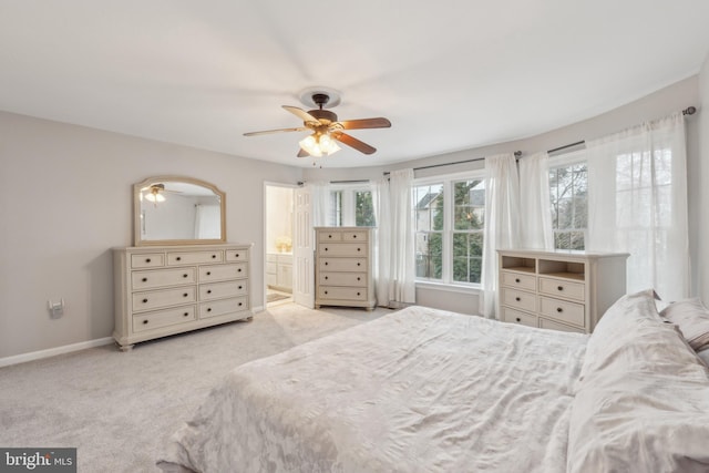 carpeted bedroom with connected bathroom, a ceiling fan, and baseboards