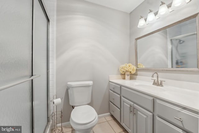 bathroom with toilet, a stall shower, vanity, tile patterned flooring, and baseboards