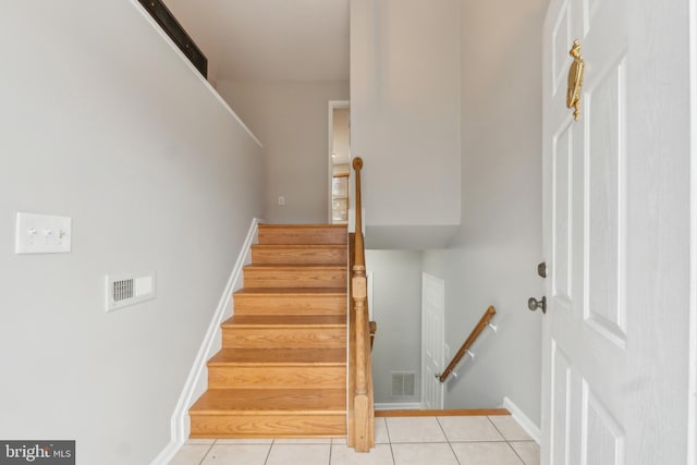 stairway with baseboards, visible vents, and tile patterned floors