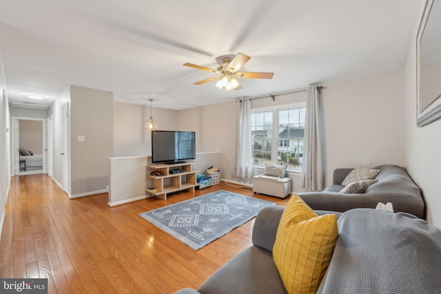 living room with ceiling fan, baseboards, and hardwood / wood-style flooring