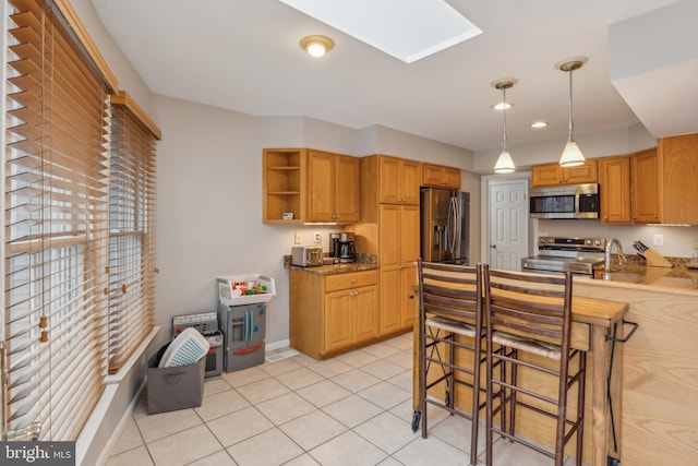 kitchen featuring light tile patterned floors, stainless steel appliances, a skylight, open shelves, and pendant lighting