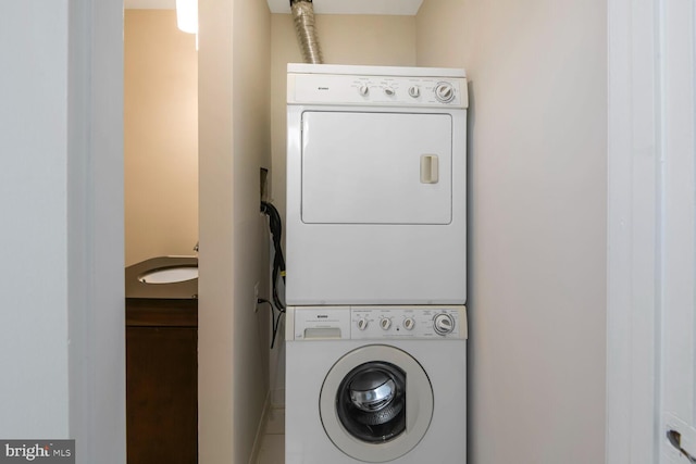 laundry area with stacked washer / drying machine and laundry area