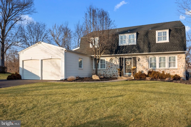 colonial inspired home featuring a garage, driveway, stone siding, roof with shingles, and a front yard