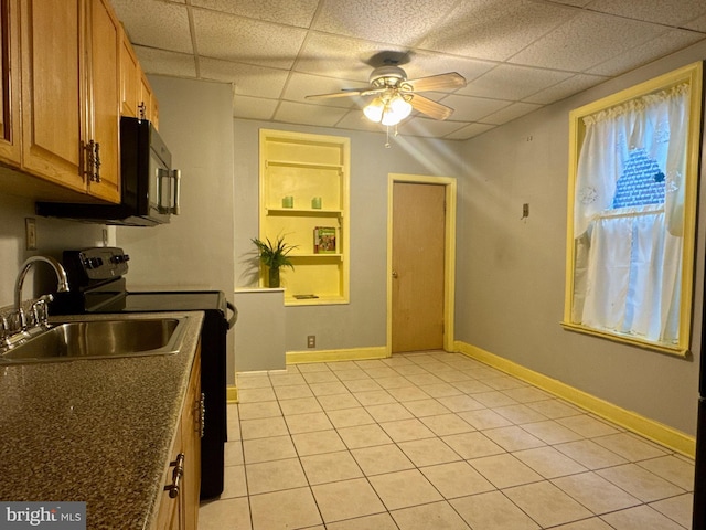 kitchen featuring baseboards, a ceiling fan, dark countertops, brown cabinets, and a sink