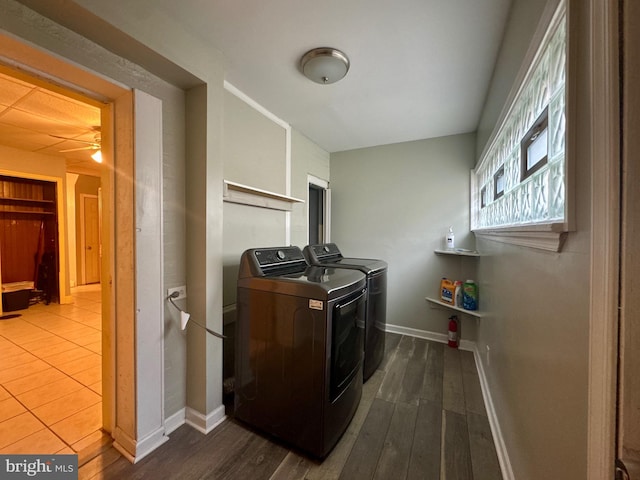 laundry area with laundry area, separate washer and dryer, dark wood-style flooring, and baseboards