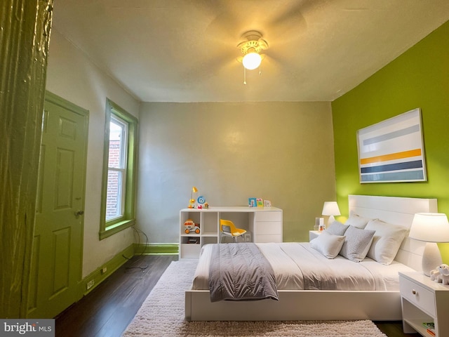 bedroom featuring dark wood-type flooring, a ceiling fan, and baseboards