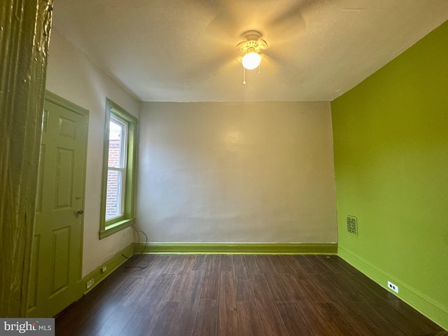 spare room featuring wood finished floors and baseboards