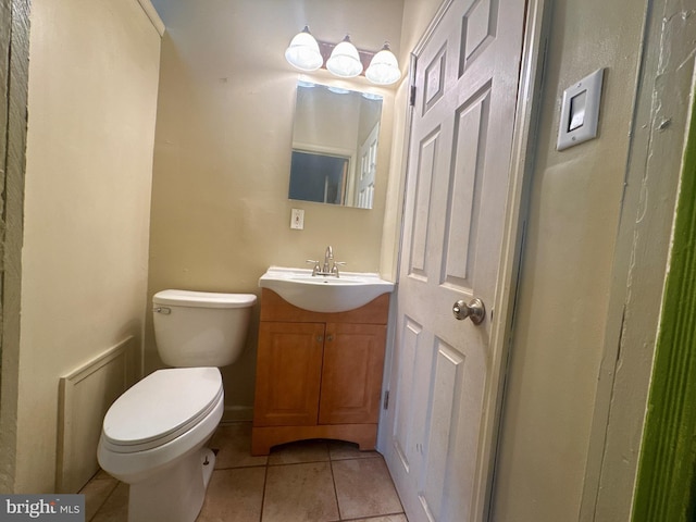 half bathroom featuring vanity, toilet, and tile patterned floors