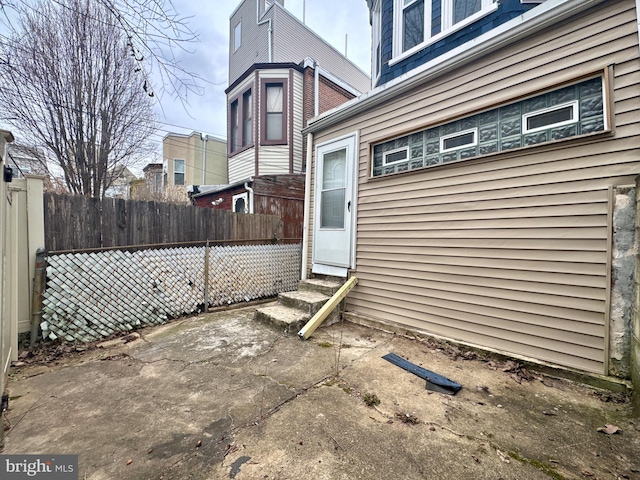 view of property exterior featuring entry steps and fence