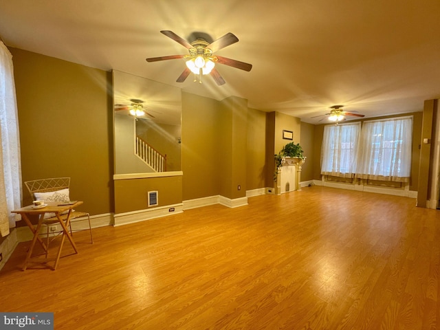 unfurnished room with a ceiling fan, baseboards, visible vents, and light wood finished floors