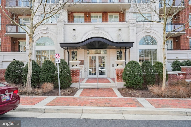 property entrance featuring french doors and brick siding