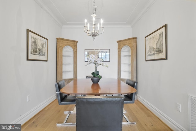 dining room featuring baseboards, light wood-type flooring, and crown molding