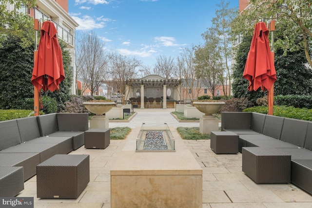 view of patio with an outdoor living space with a fire pit