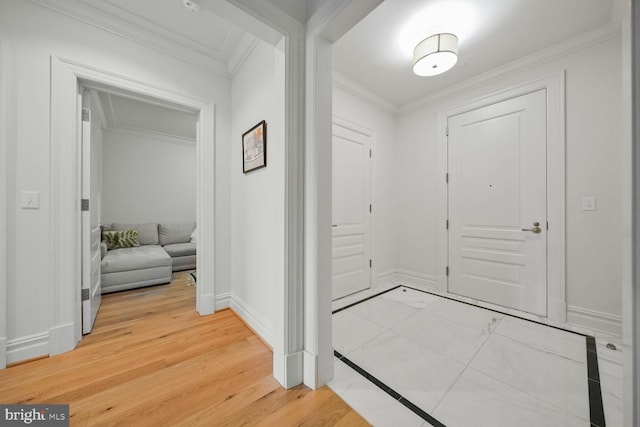 entrance foyer featuring ornamental molding, light wood-type flooring, and baseboards