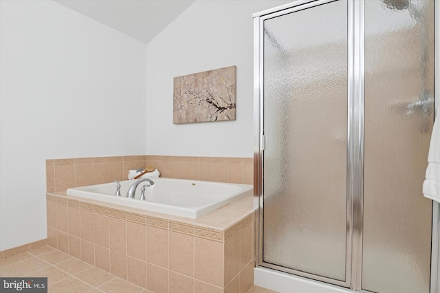 bathroom with a stall shower, tile patterned flooring, vaulted ceiling, and a bath