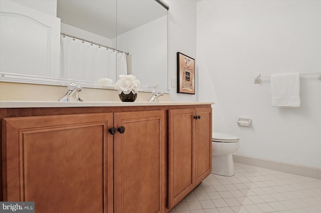 bathroom featuring baseboards, vanity, toilet, and tile patterned floors