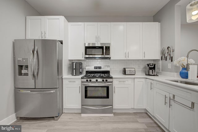 kitchen with white cabinets, stainless steel appliances, and a sink