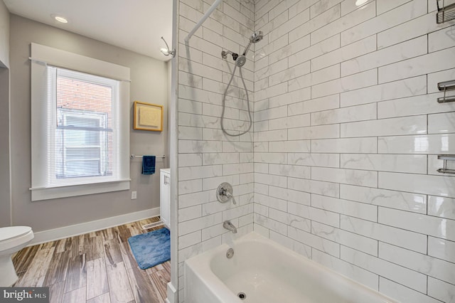 full bathroom featuring shower / bathtub combination, wood finished floors, toilet, and baseboards