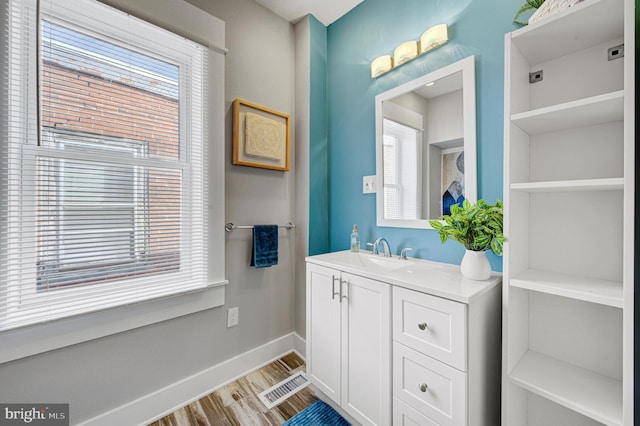 bathroom with baseboards, visible vents, a wealth of natural light, and wood finished floors