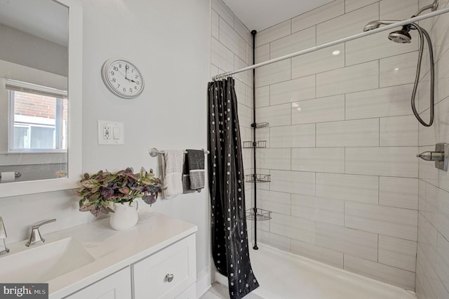 bathroom with a shower stall and vanity