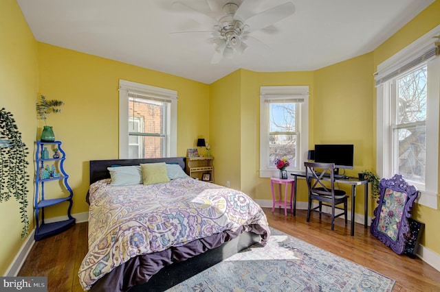 bedroom featuring ceiling fan, wood finished floors, and baseboards