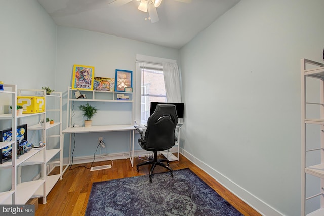 office area with visible vents, a ceiling fan, vaulted ceiling, wood finished floors, and baseboards