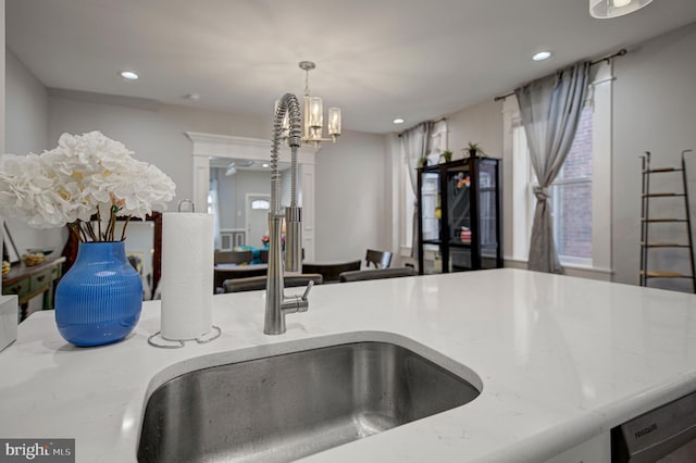 kitchen featuring light stone countertops, a sink, and recessed lighting