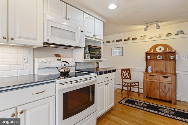 kitchen with tile counters, light wood-style flooring, baseboard heating, white cabinetry, and white appliances