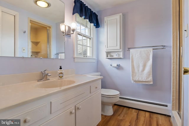 bathroom featuring toilet, a baseboard heating unit, wood finished floors, vanity, and an enclosed shower